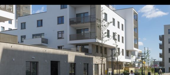 Weiße Fassade mit Würfel Balkonen hofseitig Kindergarten im Erdgeschoß © Gesiba